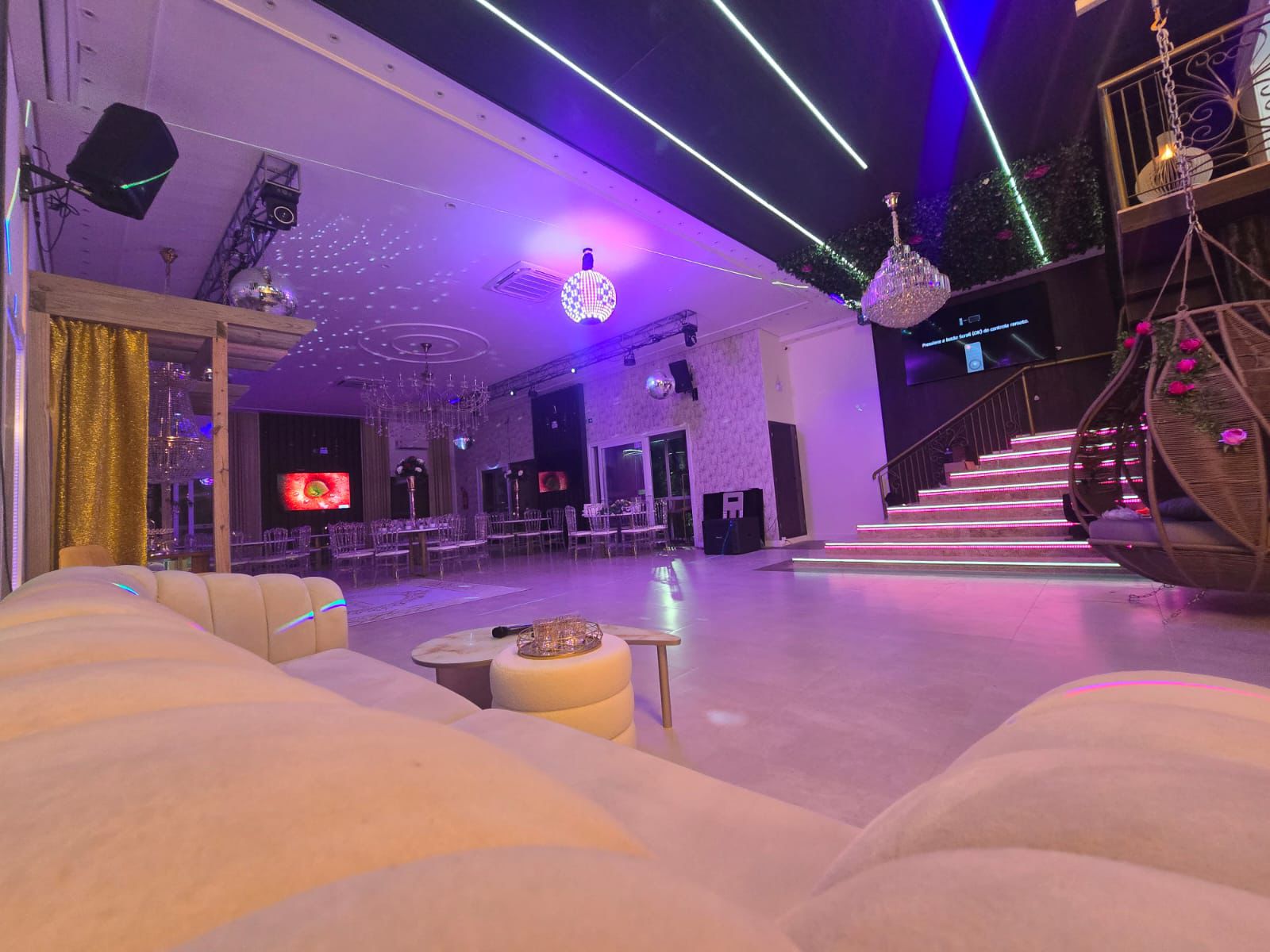Salão amplo com lounge e escadaria iluminada